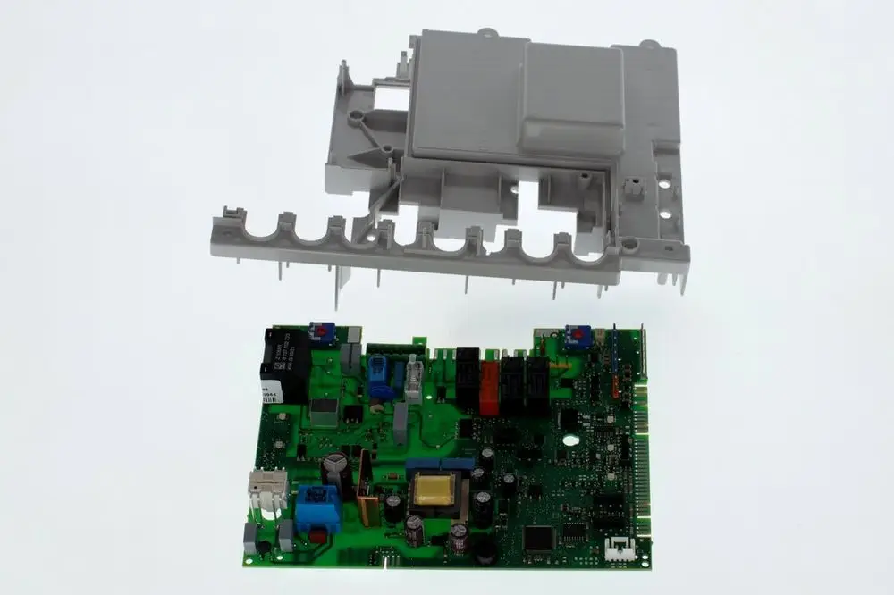 Bosch Leiterplatte mit verschiedenen elektrischen Komponenten und einem beigefügten grauen Gehäuse, teilweise abgehoben, auf hellem Hintergrund.
